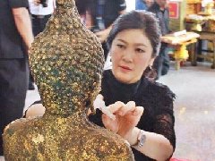 泰国前总理英拉为寺庙佛像贴金箔 民众送新年礼物加油